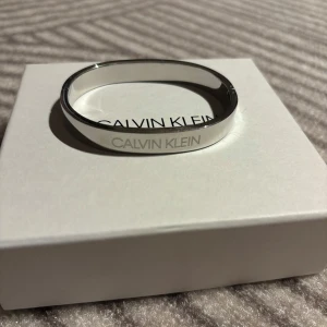 Silverfärgat Calvin Klein armband - Snyggt silverfärgat Calvin Klein armband. Säljes pga använder inte. Använd ett fåtal gånger. Du står för frakten själv. 