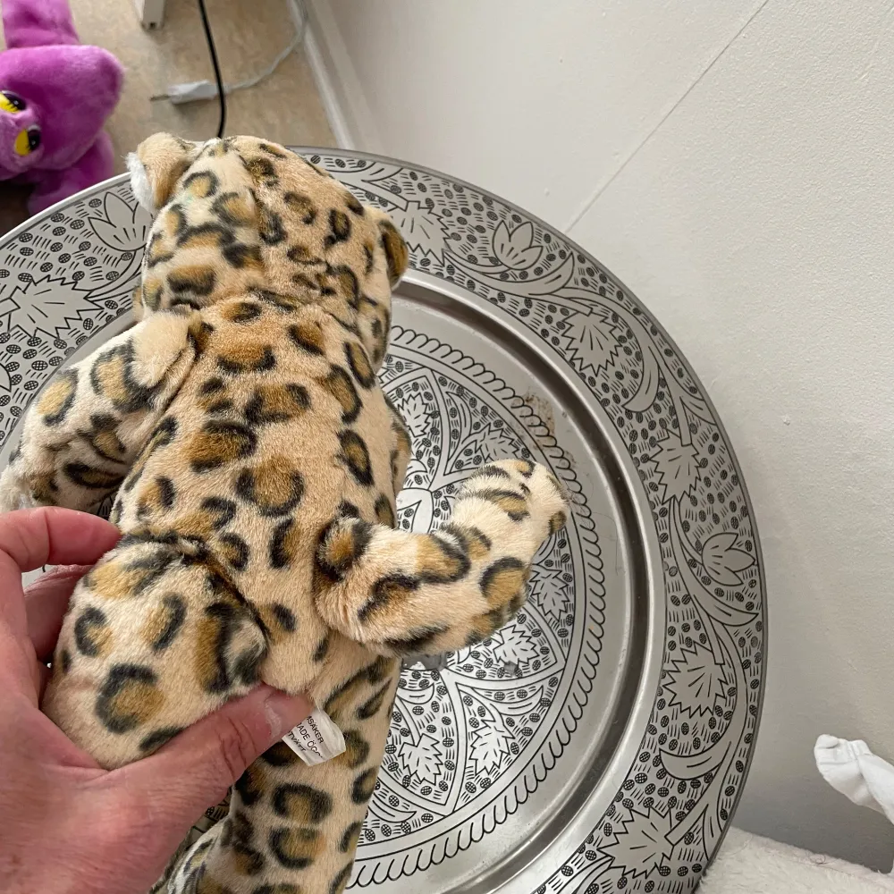 Söt vintage docka från år 1988 helt ny klädd i en leopardmönstrad dräkt .armar ,ben är rörliga.. Perfekt som dekoration eller leksak för samlare. Dockan har ansikte är i porslin med ögonfransar, .tvätta i tvättmaskinen 30 grader . Längd:33cm och bred 18cm. Asusteet.