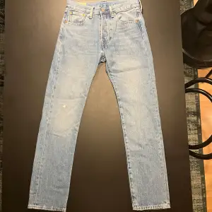 Levi’s 501 Jeans i ljusblå. Skick 10/10 använda 1-2 gånger. Köpta från Boozt nypris: 1095kr. Storlek: W28 L32. Hör av er vid frågor eller funderingar!