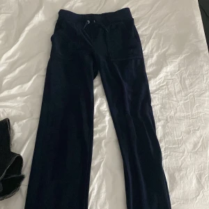 Juicy byxor  - Ett par marinblåa juicy byxor, båda metallbitarna på snörena är borta