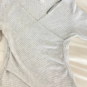 grå tröja - Grå tröja med detalj, i bra skick. Säljs för den inte används.