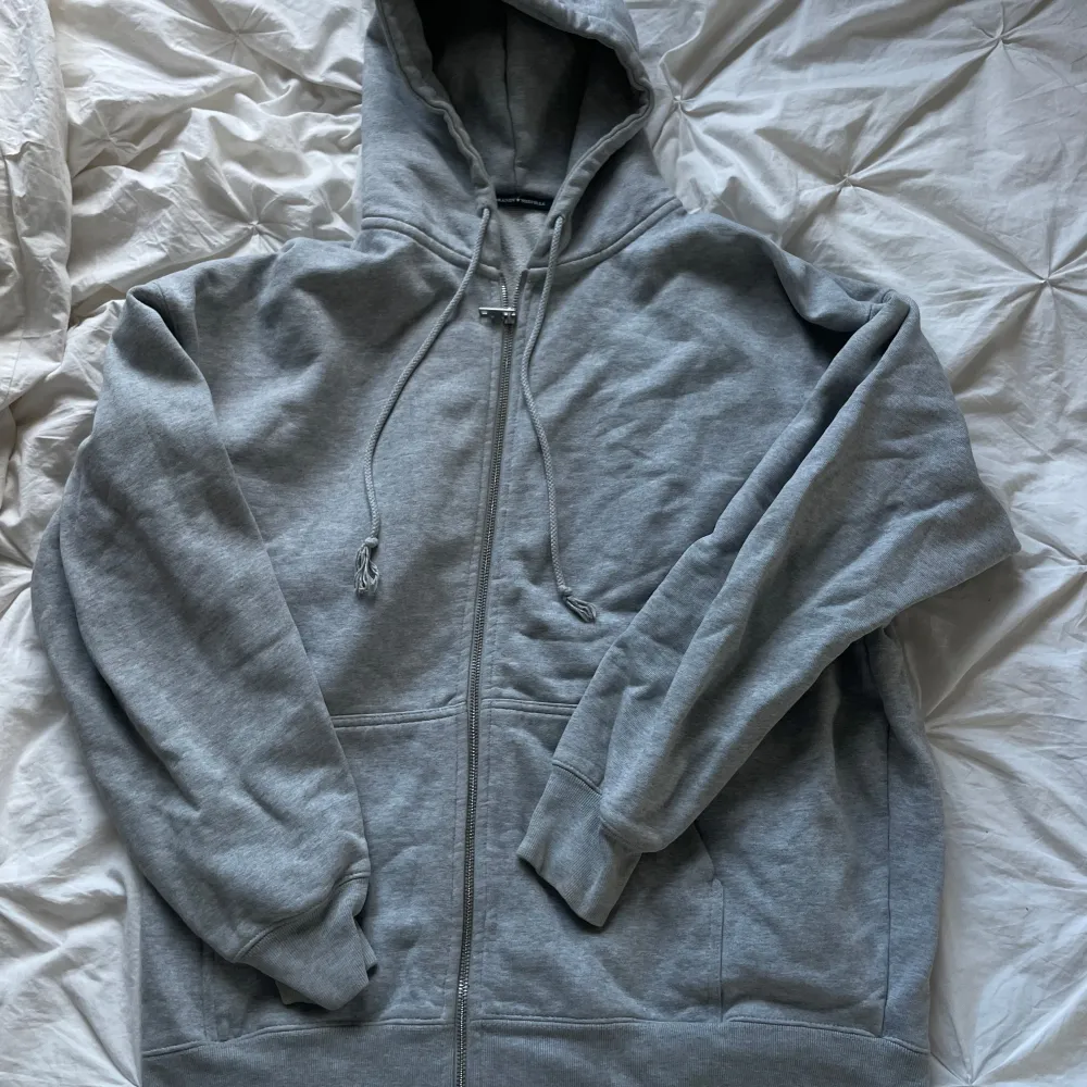 Grå hoodie från Brandy Melville. Den har en dragkedja framtill och en stor luva. Sitter som en M🥰. Tröjor & Koftor.