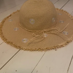Hatt - En hatt med vita blommor på
