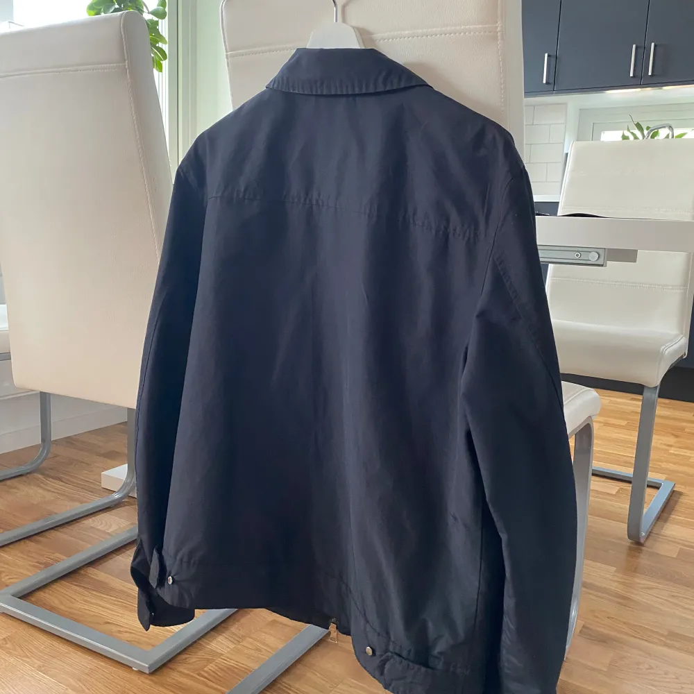 Säljer en stilren svart jacka från These Glory Days i storlek medium. Jackan har en klassisk krage och dragkedja framtill. Perfekt för höst och vår med sin enkla och tidlösa design. Den är i mycket bra skick och passar till de flesta outfits. . Takit.