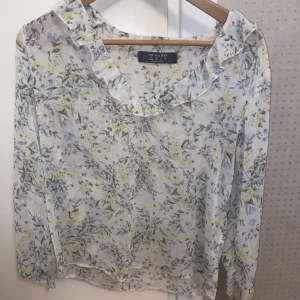 Blommig blus  - Blommig blus med fina volanger. Lite genomskinlig vilket är väldigt snyggt!