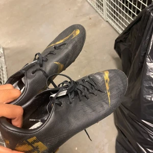 Fotbollsskor - Helsvarta med guld detaljer 