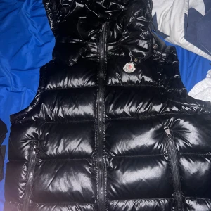 Svart dunväst från Moncler - En snygg moncler i bra skick, en knapp saknas på huvan men man lägger verkligen inte märke till det.
