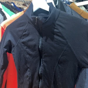 Svart långärmad jacka med dragkedja - Snygg och enkel svart jacka med dragkedja framtill. Perfekt för en casual look eller som ett extra lager under kyligare dagar. Den har en smidig passform och långa ärmar.