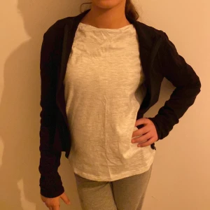 Svart jacka med dragkedja - Snygg svart jacka med dragkedja framtill. Perfekt för en casual look. Jackan har långa ärmar och en enkel design som gör den lätt att matcha med olika outfits.