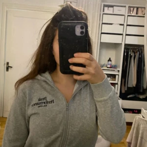 Grå hoodie från Peak Performance - Säljer en grå hoodie från Peak Performance med dragkedja och huva. Perfekt för en avslappnad stil. Märket är broderat på bröstet.