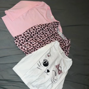 Tre tröjor från Shein till barn - Säljer tre tröjor från Shein i storlek 4år. En rosa, en med rosa leopardmönster och en vit med kattmotiv och leoparddetaljer. Perfekta för barn som gillar färgglada och lekfulla kläder.