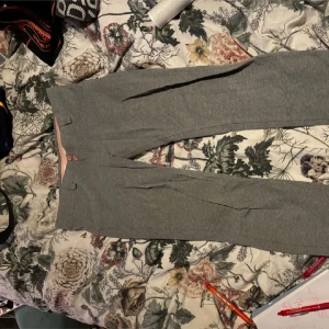 Grå byxor med knappar - Snygga grå byxor från WR.UP med hög midja och knappar framtill. Byxorna har en stilren design och är perfekta för en chic look. De är tillverkade i ett mjukt och stretchigt material för extra komfort.