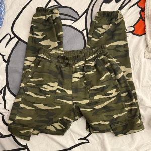 Kamouflagefärgade byxor - Snygga kamouflagefärgade byxor med elastisk midja och praktiska fickor. Materialet är tunnt och lite mjukisaktigt. De har ingen tagg så vet inte vilken storlek eller varifrån, men skulle säga de passar S. 