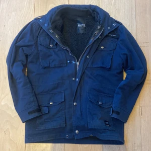 Blå jacka från Black Premium - Säljer en snygg blå jacka från Black Premium med flera praktiska fickor och dragkedja. Jackan har en mysig fleecefoder och långa ärmar, perfekt för kyligare dagar.