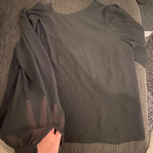 Svart topp från Object - Snygg svart topp från Object med långa ärmar och en elegant design. Perfekt för en stilren look. 