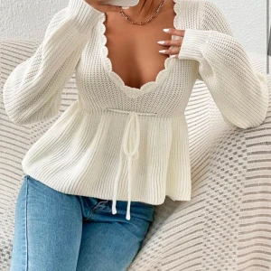 Vit stickad tröja med knyt - Säljer en söt vit stickad tröja med v-ringning och knyt framtill. Tröjan har långa ärmar och en ribbad struktur som ger en fin passform. Perfekt för kyligare dagar! Köp gärna❤️