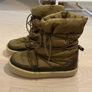 Bruna vinterboots från Isabelle Marant - Snygga och varma bruna vinterboots från Marant med snörning och vadderad design. Perfekta för kalla dagar med en robust sula och hög ankel. Stilsäkra och bekväma för vintersäsongen. Endast testade💕