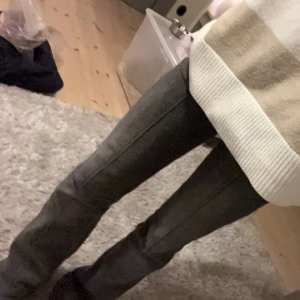 Gråa bootcut jeans - Snygga grå bootcut jeans från Bershka, tror inte dem säljs längre så vissa bilder är från en liknande modell. Jeansen har en lätt tvättad look och en rand och två knappar där fram. De är storlek 38 men kanske är lite uttöjda. Är använda men har inga stora defekter förutom där bak då är lite slitna. Fråga efter fler bilder eller om ni har fler frågor, och pris kan diskuteras! Ni står helt för frakten :)