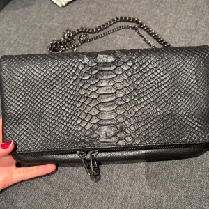 Svart zadig väska med alligator mönster  - Snygg svart axelväska med alligator mönster och två olika kedjor. Lite slitage på emblemet, men inget som märks. 