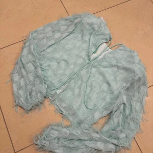 Mintgrön topp från Minimum - Säljer en mintgrön topp med långa ärmar och en unik textur. Har axelvaddar.  Aldrig använt prislapp på.