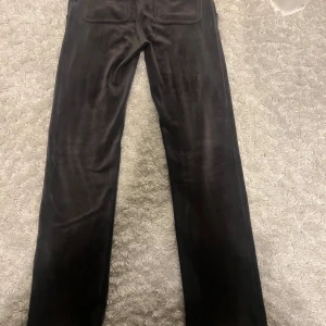 Mörkgrå byxor från Juicy Couture - Snygga mörkgrå byxor från Juicy Couture i en mjuk och bekväm stil. Perfekta för en avslappnad look med en touch av lyx.