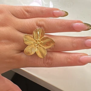 Guldfärgad blomring - Snygg guldfärgad ring formad som en blomma med fem kronblad. Perfekt för att ge en elegant touch till din outfit. Justerbar storlek för att passa de flesta fingrar. Köptes från ett uf företag🌸