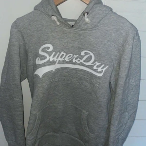 Superdry hoodie grå - Superdry hoodie grå helt oanvänd! Jätte snygg bra skick 9/10 skick. Inget täcken på användning! Pris kan diskuteras. 