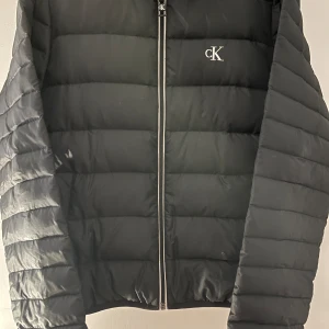 Calvin Klein jacka - Säljer den då den har blivit för liten. Ganska bra skick, men har en lagning som syns på bild 3 och nått litet hål som knappt syns.