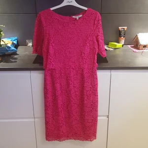 Rosa spetsklänning från KappAhl - Säljer en snygg rosa spetsklänning från KappAhl. Klänningen har korta ärmar och en dragkedja i ryggen. Perfekt för en färgglad look!