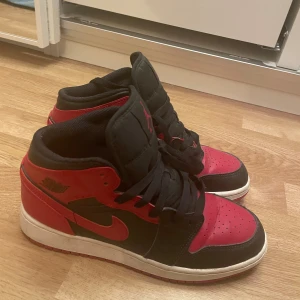 Nike Air Jordans 1 mid banned - Säljer ett par klassiska Nike Air Jordans i svart och rött. Använd ett par fåtal gånger. Tror original priset ligger på omkring 1800kr. 