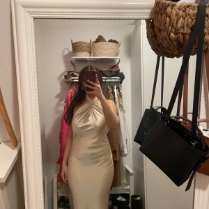 Klänning Meshki ”Laura Halter Satin Gown” - Säljer denna superfina guldiga klänningen från Meshki. Den var tänkt att ha till balen men då jag hittade en annan klänning som föll mig bättre i smaken så säljer jag denna. Den är alltså helt oanvänd med prislapp på. Den är köpt på Meshkis egna hemsida. Storlek Small. I ryggen är den öppen. För fler bilder eller frågor är det bara att skriva! Vid snabb affär kan pris diskuteras 🥰💕