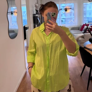 Limegrön skjorta från Bershka - Säljer en limegrön skjorta från Bershka. Skjortan har en avslappnad passform med långa ärmar och knappar framtill. Perfekt för en färgglad look!