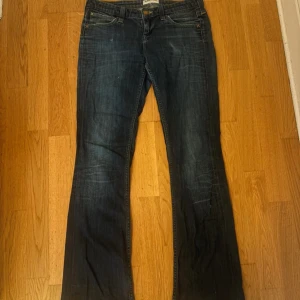 Lågmidjade Lee jeans - Snygga blå jeans från Lee, bootcut och coola bakfickor. Uppsprättade där nere men gjordes inte av mig. De är långa på mig som är 166. Inga defekter vad jag kan hitta. Midjemått 41 cm, innerben 81 cm, ytterben 103:)  