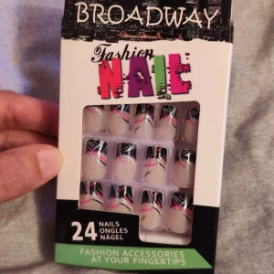 Fashion Nails från Broadway - Snygga lösnaglar från Broadway med ett coolt mönster i svart, rosa och silver. Förpackningen innehåller 24 naglar som är perfekta för att snabbt fixa en trendig look. Naglarna har en elegant design med glittrande detaljer som ger en extra touch av glamour.