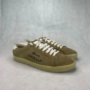 Bruna sneakers från Saint Laurent - Snygga bruna sneakers från Saint Laurent med vit snörning och en diskret logga på sidan. Skorna har en klassisk design med en bekväm sula och är perfekta för en stilren look.