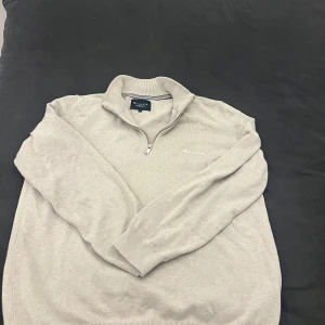 Quarter zip från bondelid  - Snygg beige tröja från bondelid med dragkedja och broderad logga på bröstet. Tröjan har långa ärmar och en ribbad krage. Perfekt för en stilren look. Pris går att diskutera