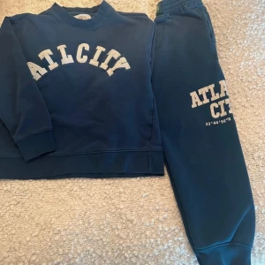 Mörkblå sweatshirt från Zara - Säljer en mörkblå sweatshirt från Zara med texten 'ATLCITY' i vitt på framsidan. Tröjan har långa ärmar och en bekväm passform. Perfekt för en avslappnad stil. 🌀