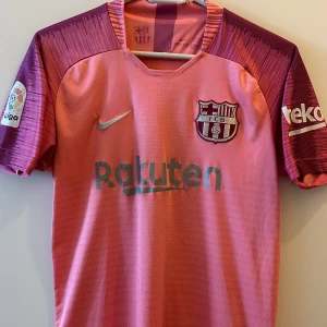 Rosa FC Barcelona fotbollströja - Jättefin och sparsamt använd Fc Barcelona Messi shirt från säsong 2018. Vill egentligen ej bli av med den men den passar ej längre, någon annan kanske får bättre användning för den! Storlek 170, men motsvarar en S för mig! Exakt som i bild, lägg märke till att stygnen har gått upp på vissa ställen.  Äkta och Rare piece!