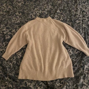 Beige stickad tröja från H&M - Säljer en mysig beige stickad tröja från H&M, lite längre i kroppen då den var mer klänning förut men nu krympt i tvätten. Verkligen jätteskön att ha på sig🥰 Är väl använd men mycket bra skick ändå! Lite knopprig men annars inga defekter🌸
