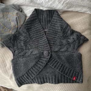 Grå stickad väst med knapp - Jättefin bolero, säljs då jag inte använder den. Står i den storlek L, men är en xs, s!