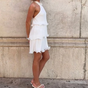 Studentklänning  - Jättefin kort klänning med knytning och volanger😍😍😍 perfekt till studenten!! Klänningen är i storlek 32 men kan anpassas lite pga knytningen, skulle säga att den passar en xs bäst! Helt slutsåld i denna storleken!!!