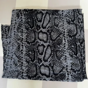 Svart och grå halsduk från By Malene Birger - Snygg och trendig halsduk från By Malene Birger med ett djärvt mönster i svart och grått. Perfekt för att ge din outfit en edgy touch. Halsduken är stor och kan bäras på flera olika sätt.