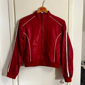 Röd jacka - Snygg röd jacka från Mosaic med dragkedja och vita detaljer. Det står att storleken är L men skulle säga att den passar mer för en s/m beroende på önskad passform🌟