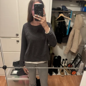 Grå tröja från Zara - Säljer en stilren grå tröja från Zara med rund hals och långa ärmar. Tröjan har en avslappnad passform och ribbade muddar vid ärmslut och nederkant. Perfekt för en casual look.