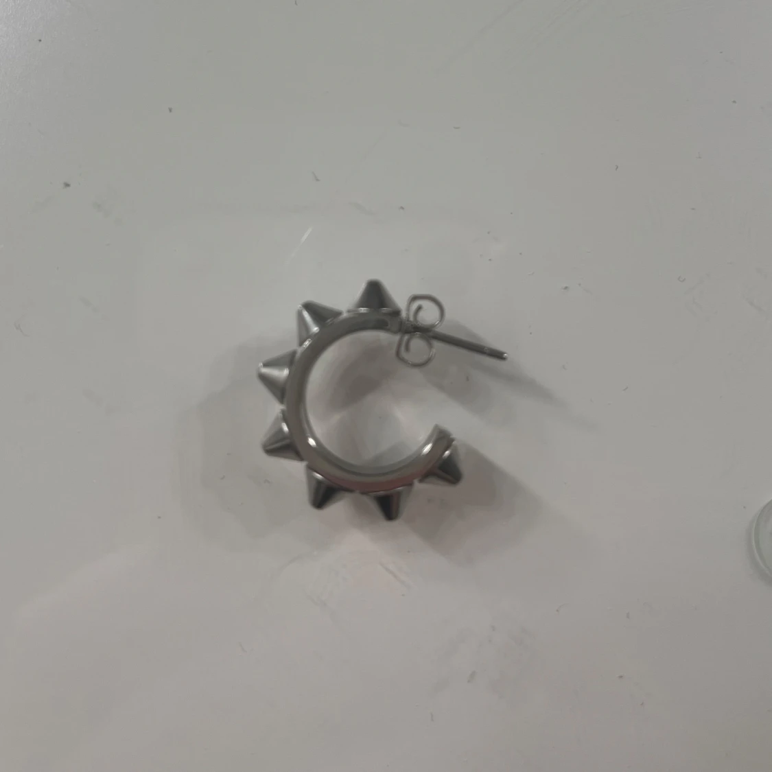 Silverfärgat örhänge med nitar