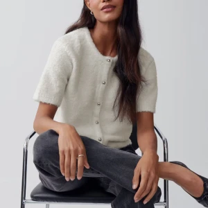 Vit kofta med kort ärm och knappar - Säljer en mysig vit kofta med korta ärmar och knappar framtill. Har bara ändvänt den 1 gång så den är som ny!😍