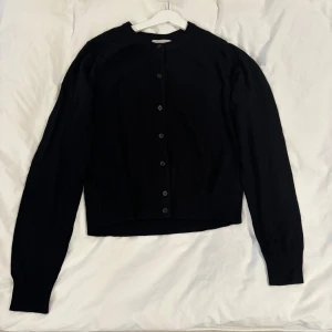 Svart kofta från H&M - Svart kofta från H&M med knappar framtill. Aldrig använd och i storlek M men passar även S! 