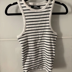 Randigt linne - Jag säljer ett vit och svart randigt linne från Bikbok. Fint linne som aldrig använts.