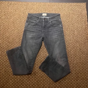 Grå jeans från Jack & jones - Snygga grå jeans från Nudie Jeans med klassisk femficksdesign och knappgylf. Perfekta för en avslappnad stil med en modern touch.