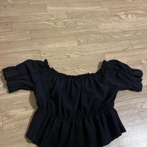 Svart offshoulder topp - Snygg svart offshoulder topp från SHEIN  med elastiska detaljer vid hals och midja. Storlek M 